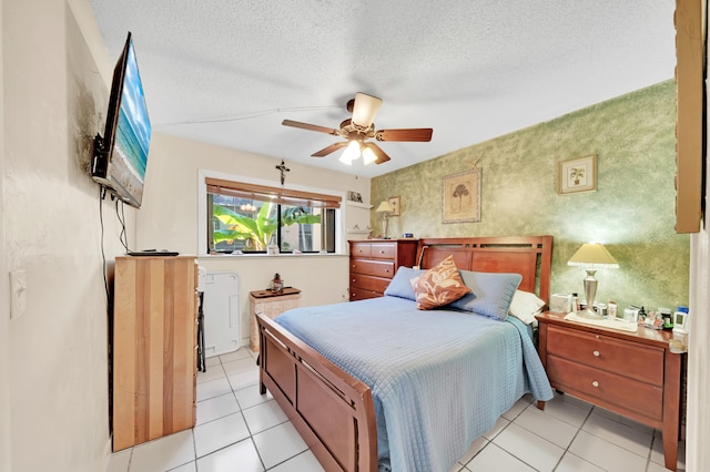 tiled bedroom with a textured ceiling and ceiling fan