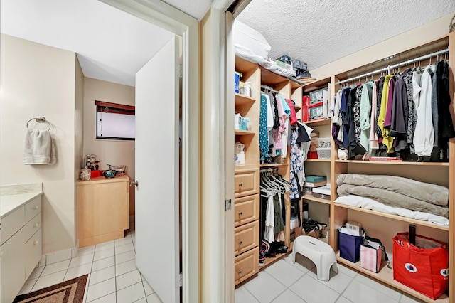 walk in closet with light tile patterned floors