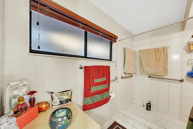 bathroom featuring tile patterned flooring and tiled shower