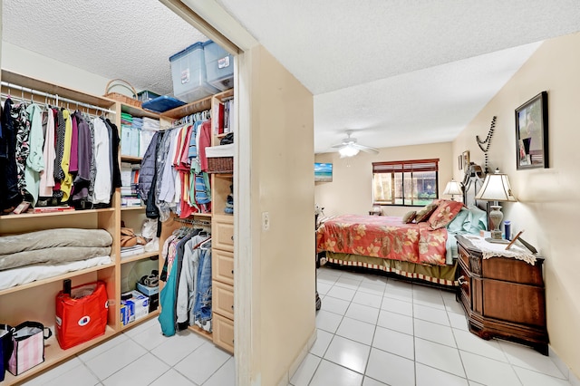 bedroom with ceiling fan, a closet, light tile patterned floors, and a textured ceiling