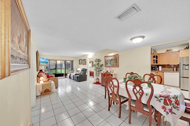 dining space with a textured ceiling and light tile patterned flooring