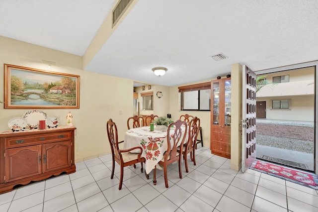 dining room with light tile patterned floors and a textured ceiling