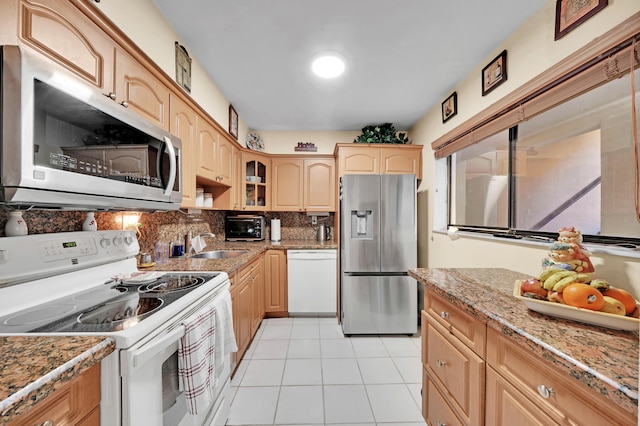 kitchen with sink, light brown cabinets, backsplash, light tile patterned floors, and appliances with stainless steel finishes