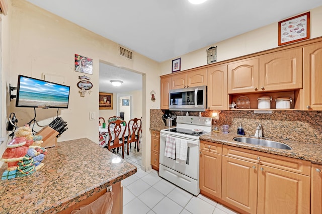 kitchen featuring backsplash, light stone counters, sink, light tile patterned floors, and electric range