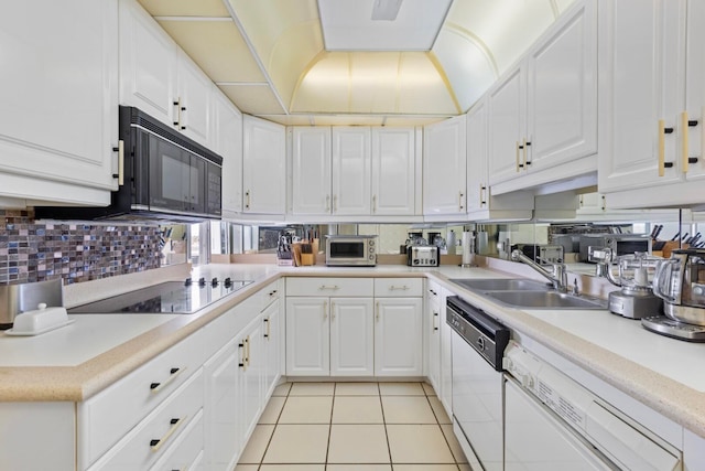 kitchen with tasteful backsplash, white cabinetry, sink, and black appliances