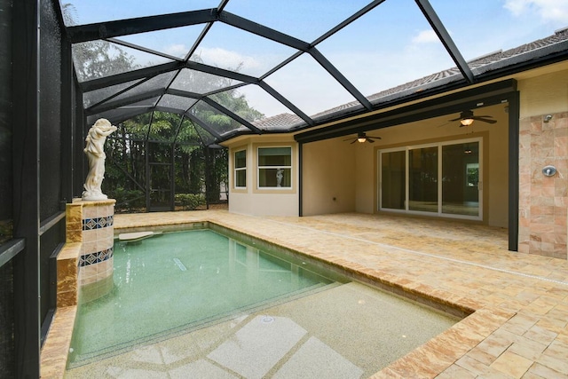 view of pool featuring glass enclosure, ceiling fan, and a patio area