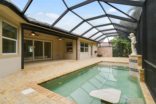 view of swimming pool with glass enclosure, ceiling fan, and a patio