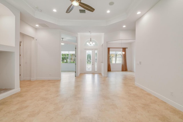 interior space featuring a tray ceiling, crown molding, and ceiling fan with notable chandelier