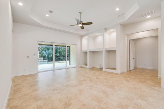 unfurnished living room featuring crown molding, ceiling fan, built in features, a towering ceiling, and a tray ceiling