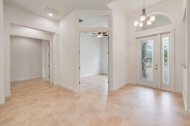 foyer entrance featuring ceiling fan with notable chandelier and crown molding