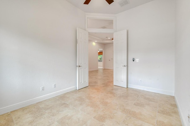 spare room featuring ceiling fan and a towering ceiling