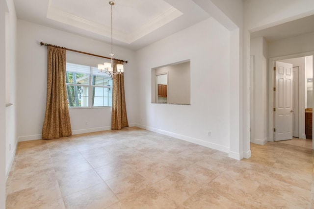 empty room with a raised ceiling, crown molding, and an inviting chandelier