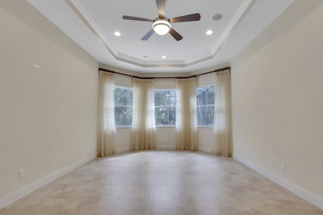 unfurnished room with ceiling fan, ornamental molding, light tile patterned floors, and a tray ceiling