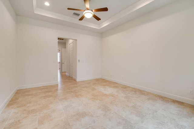 spare room featuring a tray ceiling, ceiling fan, and ornamental molding