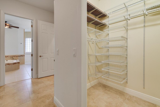 walk in closet with tile patterned flooring and ceiling fan