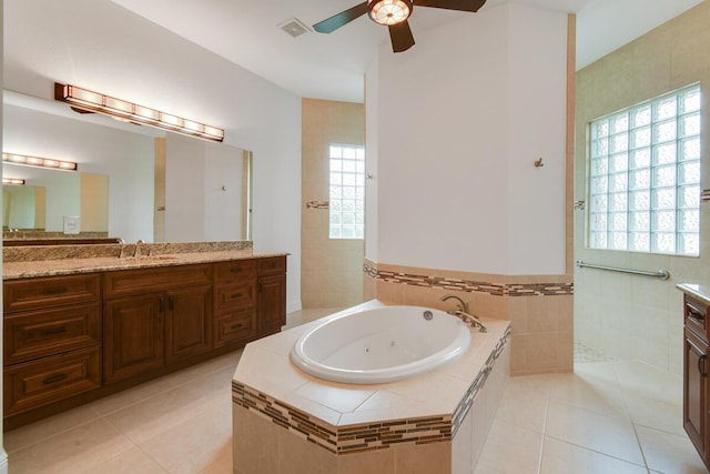 bathroom featuring tile patterned floors, a relaxing tiled tub, and a healthy amount of sunlight