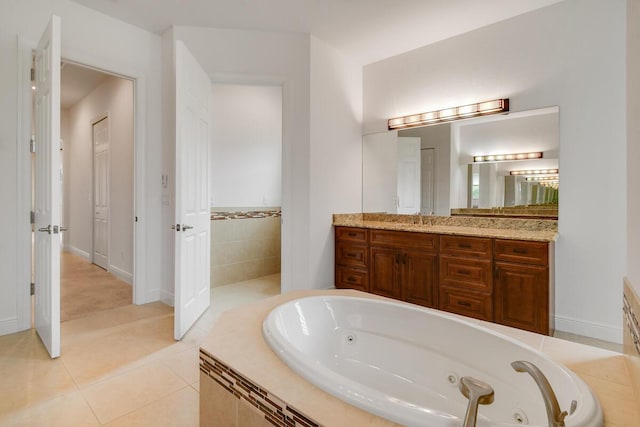 bathroom featuring tiled tub, tile patterned flooring, and vanity