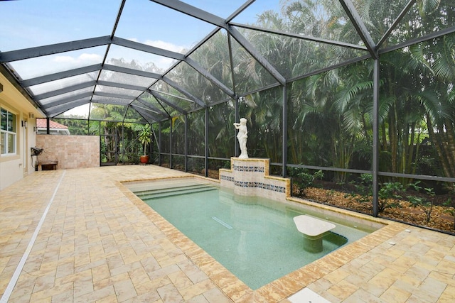 view of swimming pool featuring glass enclosure and a patio area