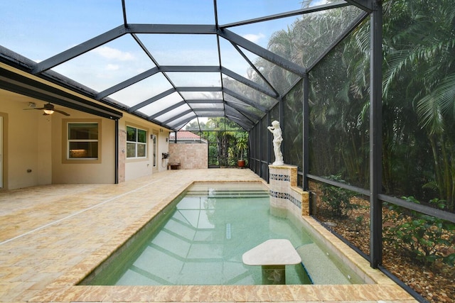 view of pool with glass enclosure, ceiling fan, and a patio