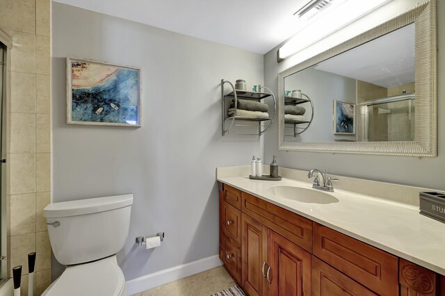 bathroom with tile patterned flooring, vanity, an enclosed shower, and toilet