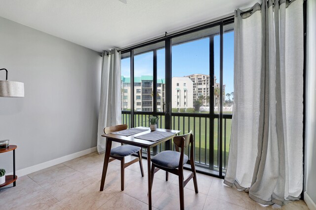 dining area featuring light tile patterned floors and expansive windows