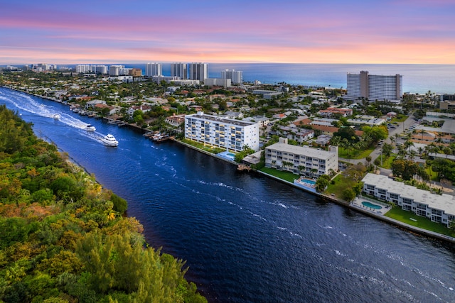 aerial view at dusk featuring a water view