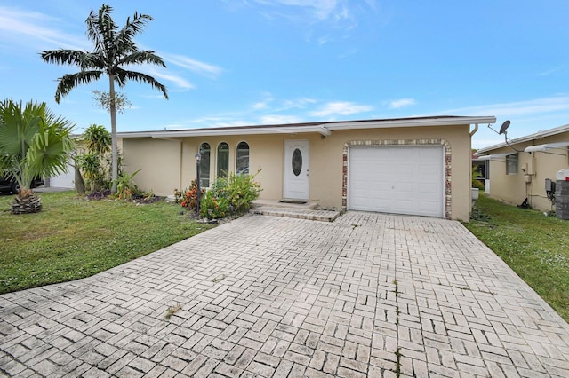 single story home with a garage and a front lawn