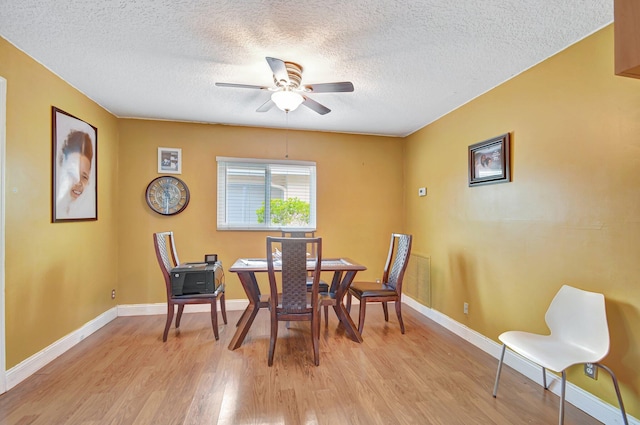 dining space featuring ceiling fan, light hardwood / wood-style floors, and a textured ceiling