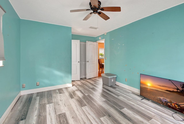 unfurnished bedroom with ceiling fan and light wood-type flooring