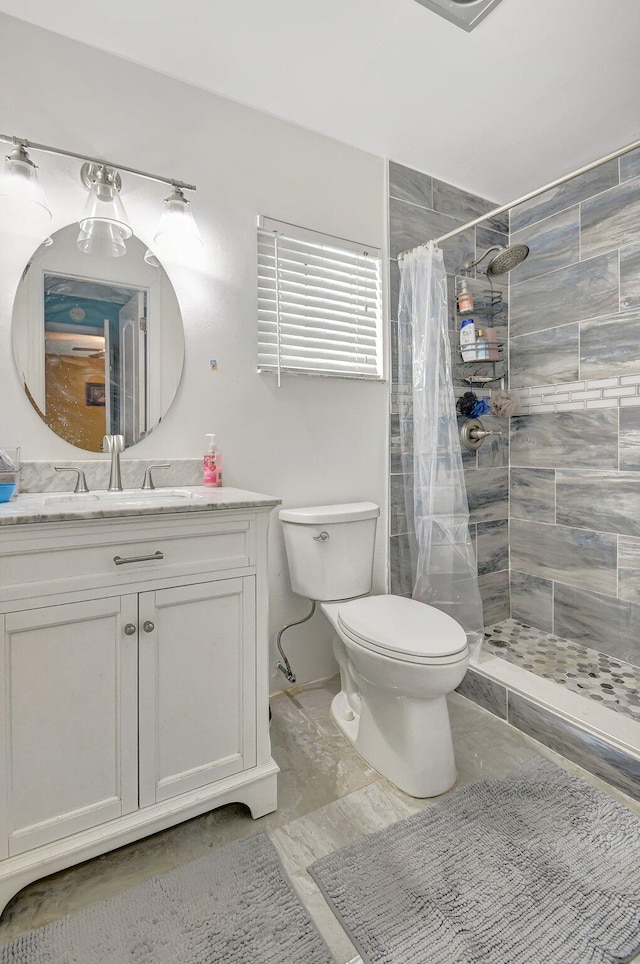 bathroom featuring a shower with shower curtain, vanity, and toilet