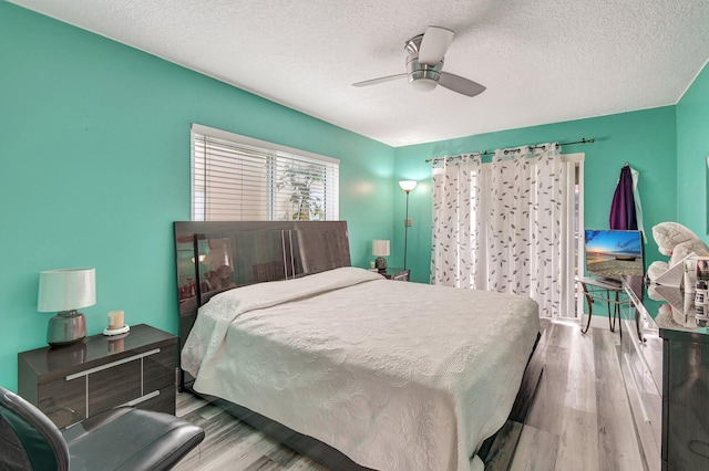 bedroom featuring ceiling fan, light hardwood / wood-style floors, and a textured ceiling