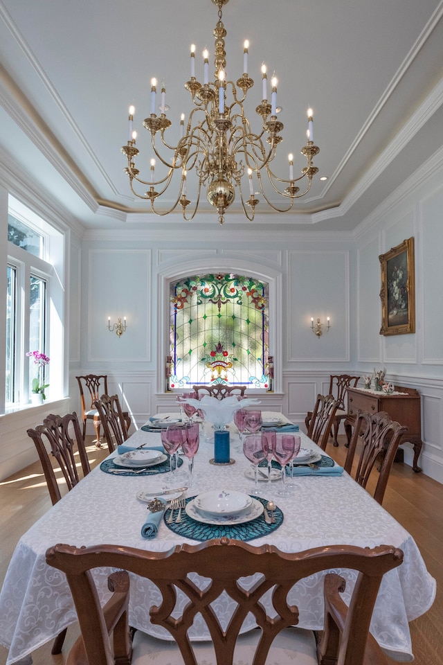 dining space with crown molding, a chandelier, and hardwood / wood-style flooring