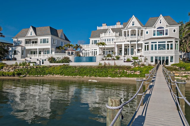 rear view of property with a water view and a balcony