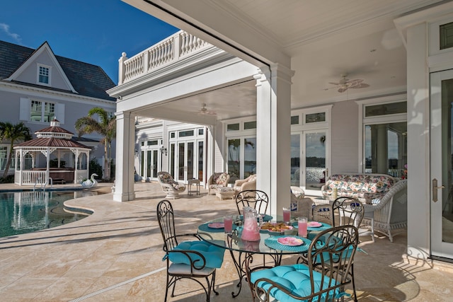 view of patio / terrace featuring a gazebo, ceiling fan, and a balcony