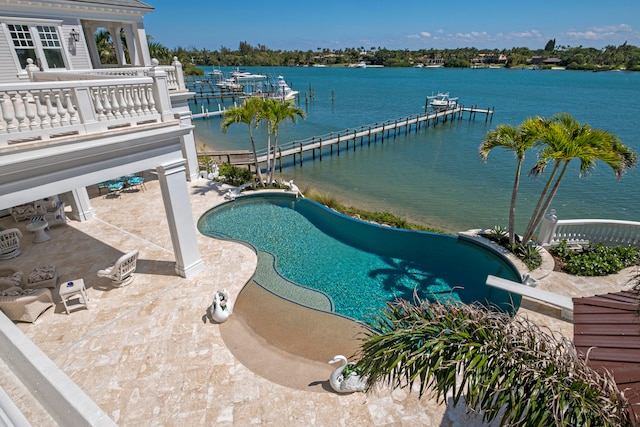 view of pool with a diving board, a water view, and a patio