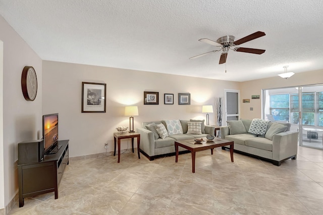 living room with ceiling fan and a textured ceiling