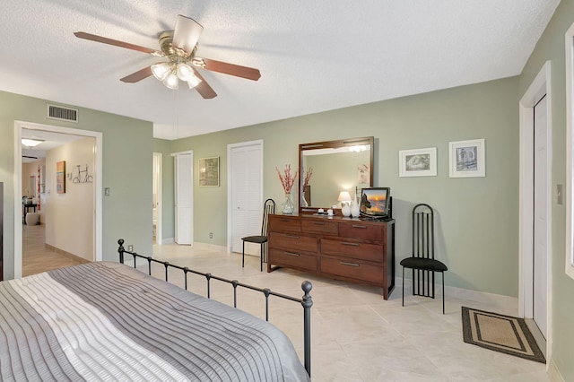 bedroom with a textured ceiling and ceiling fan