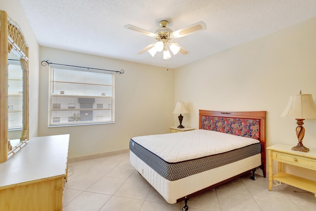 bedroom featuring ceiling fan, light tile patterned flooring, a textured ceiling, and multiple windows