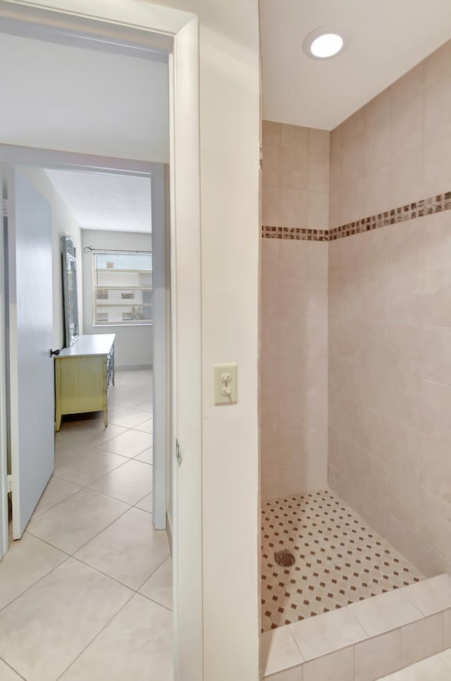 bathroom with tile patterned flooring and a tile shower