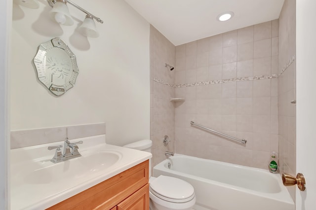 full bathroom featuring vanity, tiled shower / bath combo, and toilet