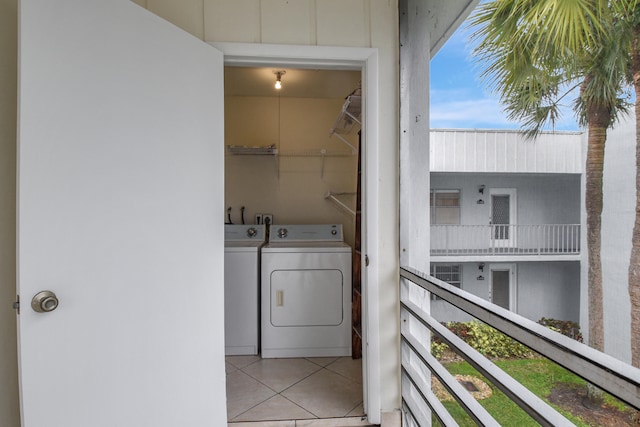 laundry area with independent washer and dryer and light tile patterned floors