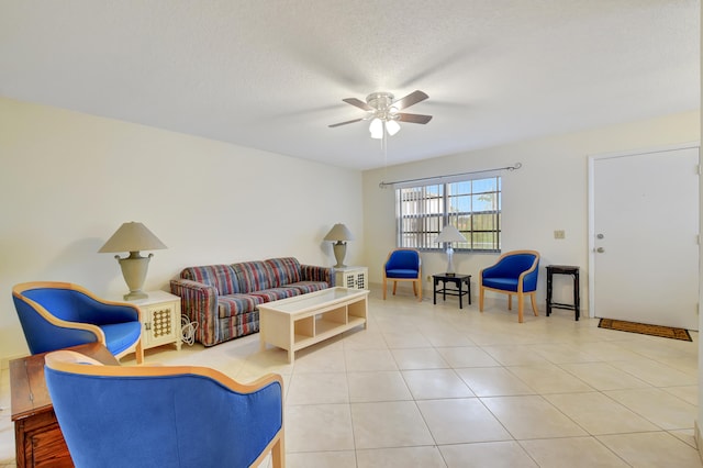 living room featuring ceiling fan, tile patterned flooring, and a textured ceiling