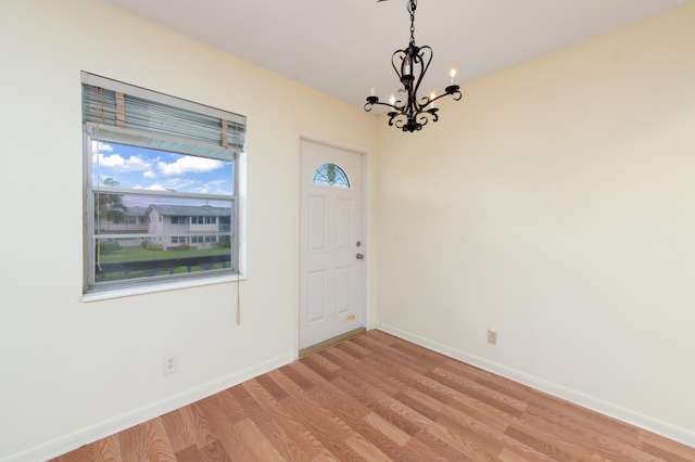 foyer entrance featuring light wood-type flooring and an inviting chandelier