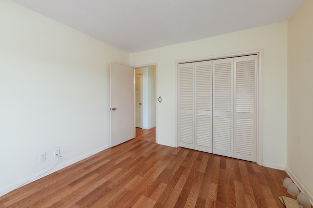 unfurnished bedroom with hardwood / wood-style floors and a closet