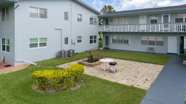 exterior space featuring a lawn, central air condition unit, and a patio