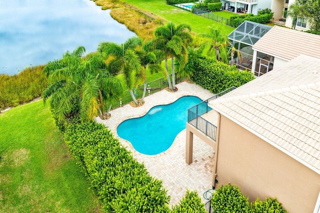 view of swimming pool with a lanai, a patio area, a water view, and a lawn