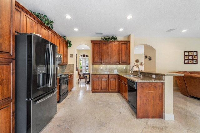 kitchen featuring kitchen peninsula, backsplash, a textured ceiling, sink, and black appliances