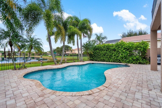 view of swimming pool with a water view and a patio area