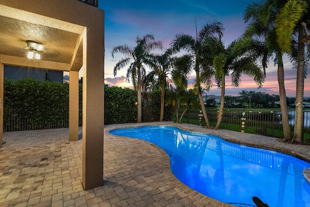 pool at dusk with a patio