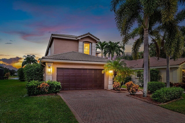 view of front of home with a yard and a garage